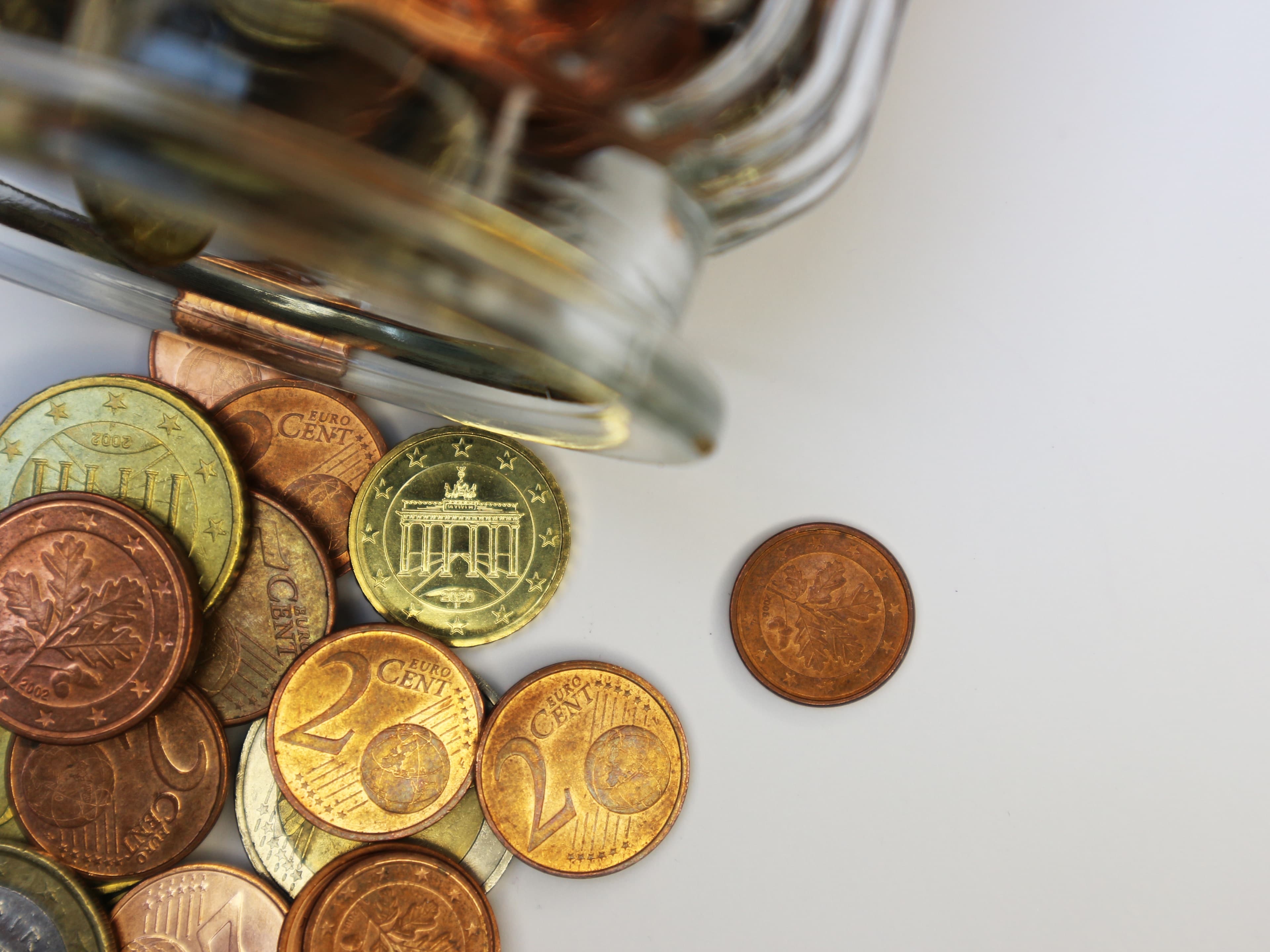 Coins and a calculator arranged beside investing notes.